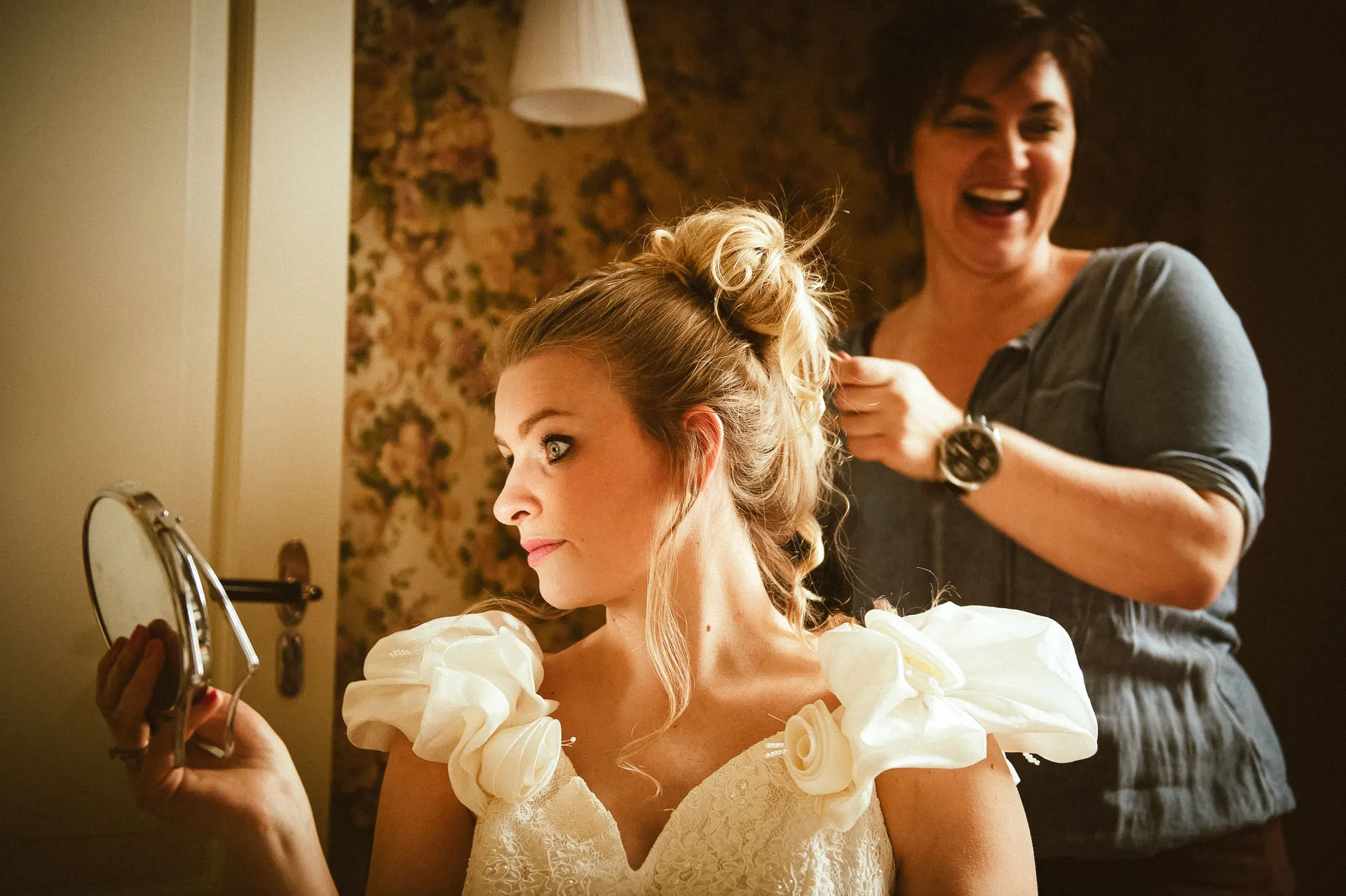 Bride smiling while her hair is styled on the morning of her wedding