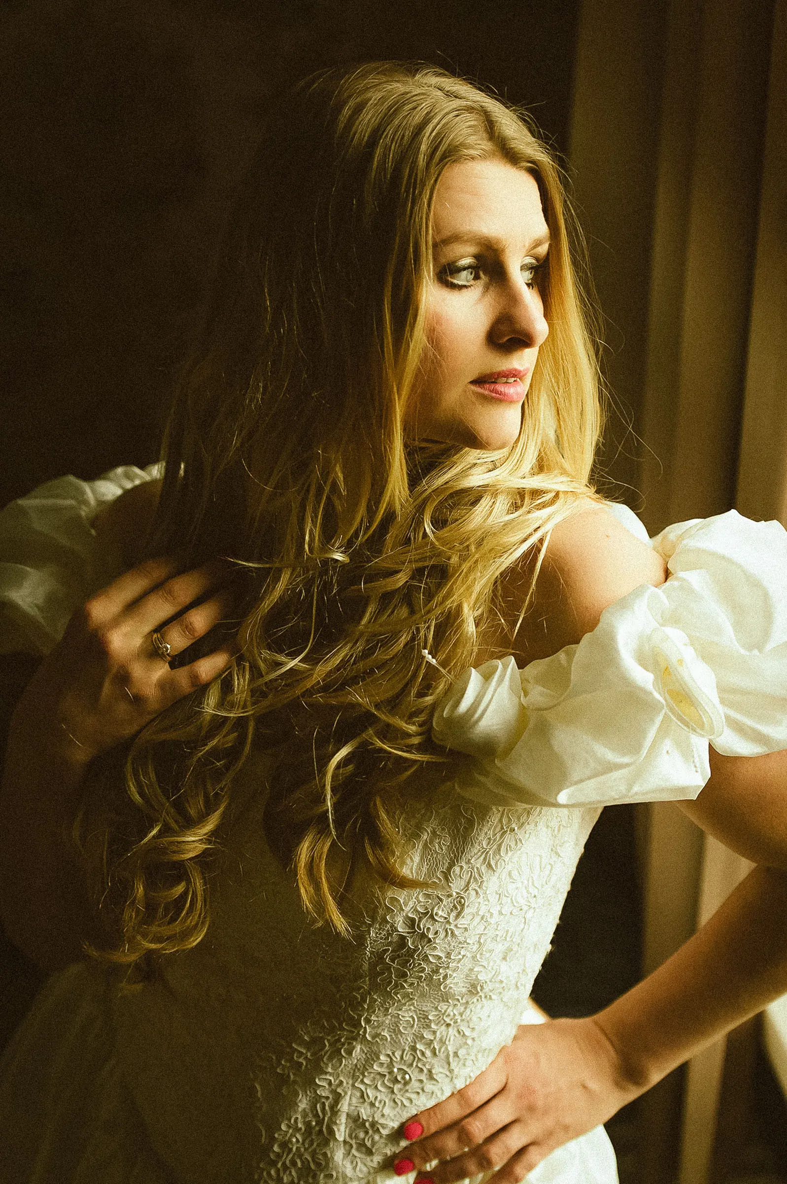 Bride in a lace wedding dress portrayed in warm dramatic light